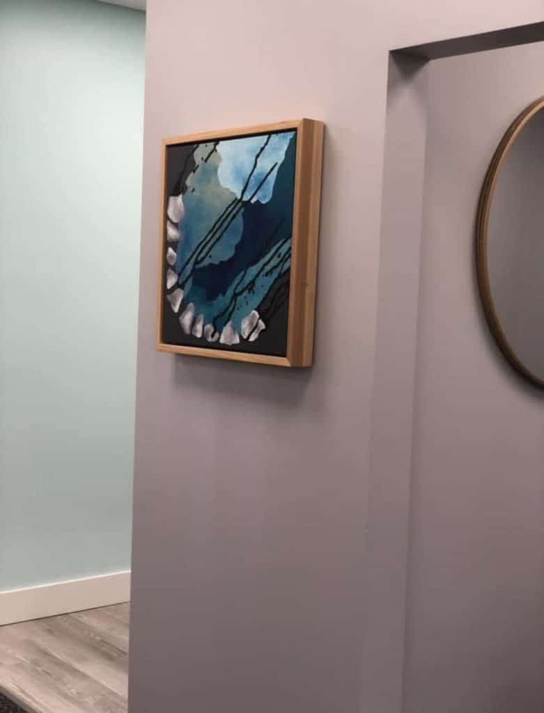 Artwork by Anne blue painting hanging in a home